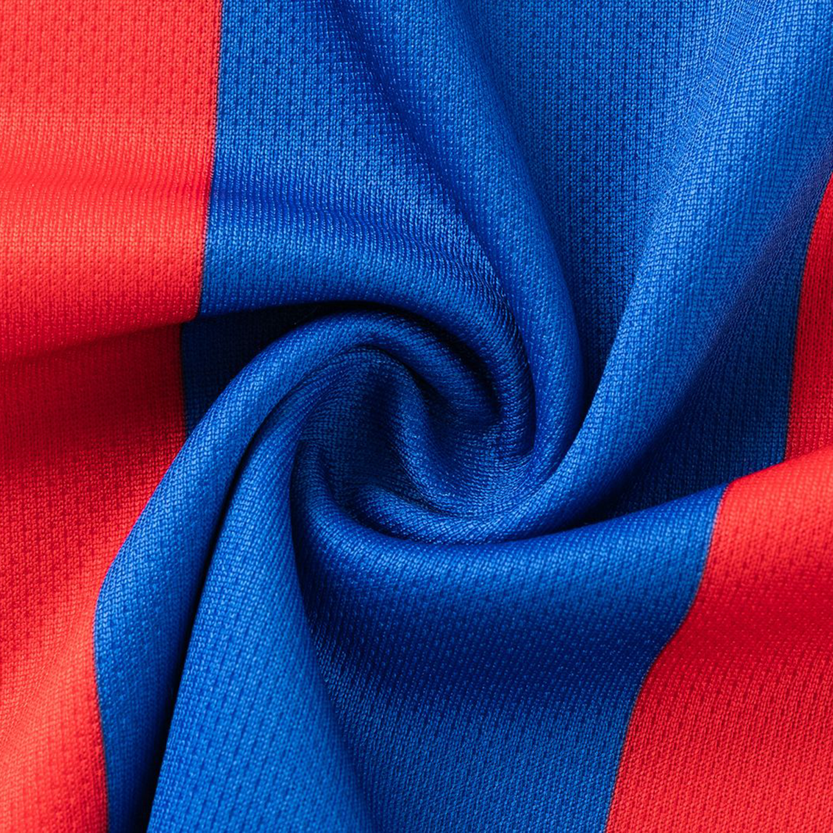 Close-up of red and blue textured fabric spiraled together, capturing the dynamic style of the Knights NRL 26/27 Replica Home Jersey by Classic Sportswear.