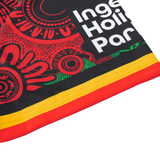Close-up of fabric with Indigenous-inspired red, green, and yellow patterns, plus partial text "Inge Hoi Par"—a unique detail from the Rabbitohs Indigenous NRL 25/26 Replica Jersey by Classic Sportswear.