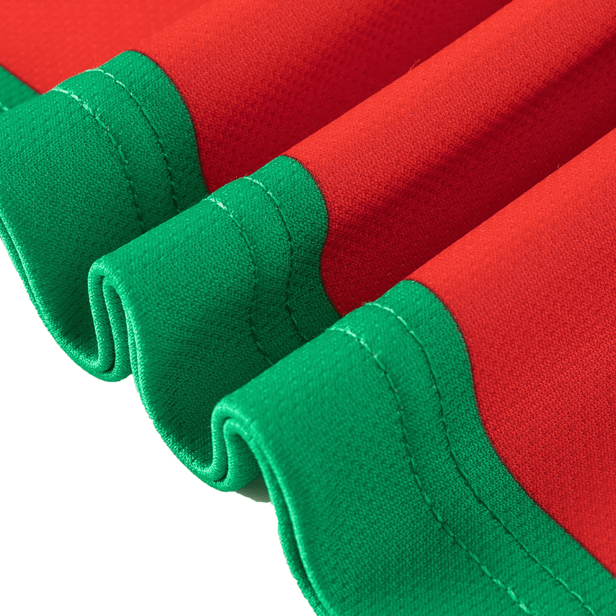 A close-up of red fabric with green stitching and edges from the Rabbitohs NRL 25/26 Replica Home Jersey by Classic Sportswear shows three curved folds, capturing a classic sportswear design.