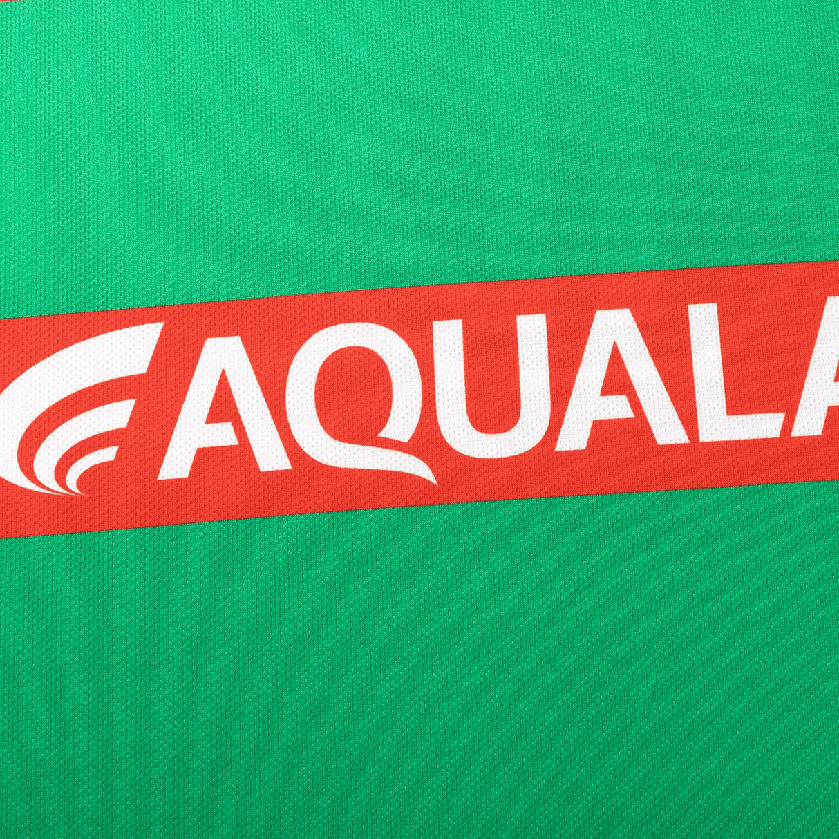 A green background with a red diagonal stripe showcases "AQUALAND" in bold white letters, echoing the style of the Rabbitohs NRL 25/26 Replica Home Jersey by Classic Sportswear.