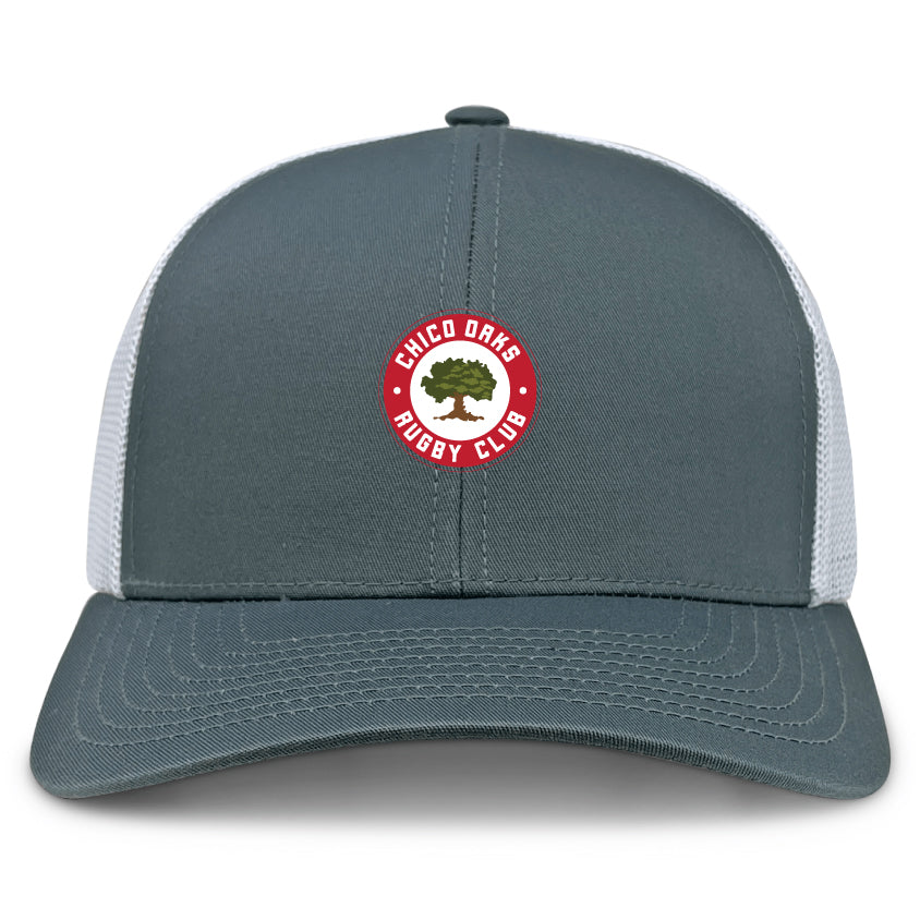 The Chico Oaks Retro Trucker Cap by EMB S&S Activewear features a gray and white design, an embroidered circular red "Chico Oaks Rugby Club" logo with a green oak tree on the front, and an adjustable classic snapback closure.