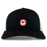 The Chico Oaks Retro Trucker Cap by EMB S&S Activewear features a black and white design, circular "Chico Oaks Rugby Club" embroidery with an oak tree on the front, and an adjustable snapback closure.