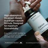A hand holds a bottle of Momentous Calcium, while another hand takes out capsules. Product details and certifications appear on the left, emphasizing calcium’s role in supporting bone strength.