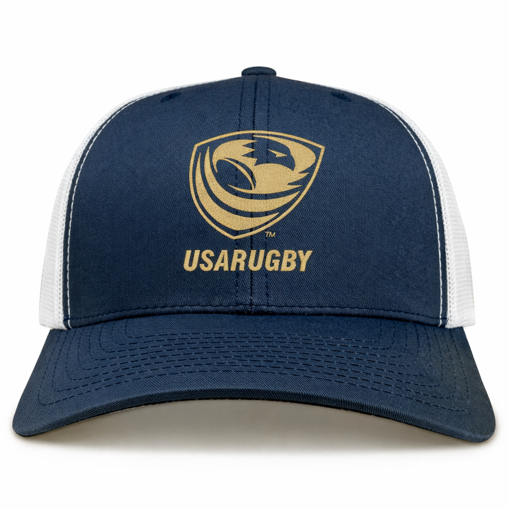 The EMB S&S Activewear USA Rugby Bronze Retro Trucker Cap is a navy blue and white hat featuring the USARUGBY logo and gold text on the front panel.