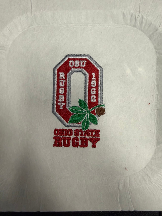 The Ohio State University Alumni EMB Logo by EMB World Rugby Shop features an embroidered red "O," buckeye leaf and nut, and the text "OSU Rugby 1966" and "Ohio State Rugby" on white fabric.