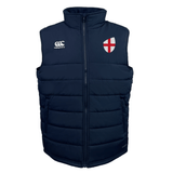 EMB Canterbury's England Shield Core Gilet is a navy blue padded vest with a zipper, featuring a white logo on the left chest and an England flag emblem on the right. It incorporates Thermoreg Insulation for optimal warmth and comfort.