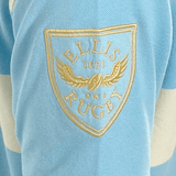 Close-up of the Ellis Rugby Argentina Rugby Polo in light blue and white, made from 100% cotton, featuring the embroidered Ellis Rugby logo with wings and a rugby ball.