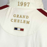 The back of the Ellis Rugby 21 Club Collection 1997 France Polo, by Ellis Rugby, features gold embroidery with "1997" at the top and "GRAND CHELEM" in the center, along with a small French flag below. Red stripes adorn the shoulders.
