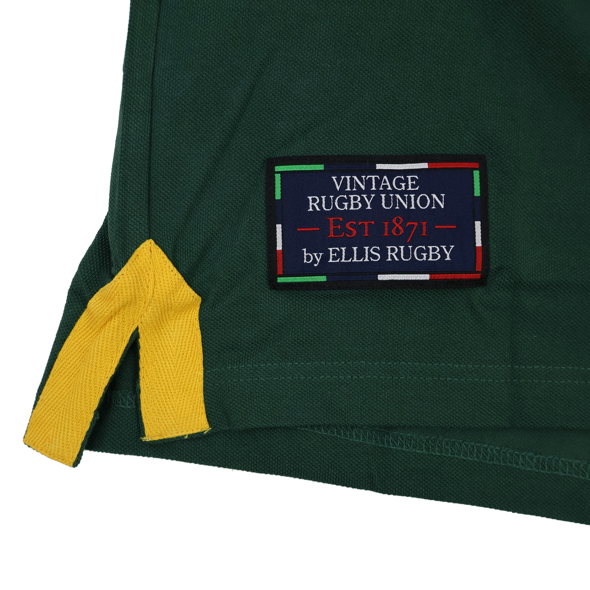 Close-up of a green fabric featuring a yellow corner detail and a patch reading “Vintage Rugby Union Est 1871 by Ellis Rugby,” bordered in red, green, white, and blue—capturing the classic look of the Ellis Rugby South Africa Rugby Polo 1924 by Ellis Rugby, inspired by iconic Springbok rugby heritage.