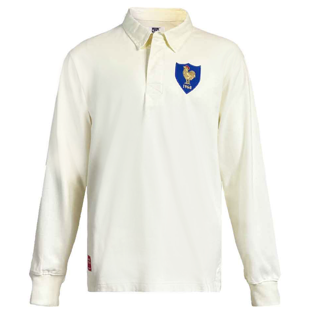 This France 1968 Grand Slam Classic Rugby Shirt by Ellis Rugby is a timeless piece with a white long-sleeve design, featuring a blue crest and gold figure on the chest. Celebrate rugby heritage with this vintage design from Ellis Rugby.