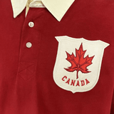A red Ellis Rugby 21 Club Collection 1902 Canada Rugger shirt with a maple leaf on it, by Ellis Rugby.