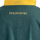 This green and yellow garment, the Ellis Rugby Springbok 1995 Vintage Long Sleeve Rugby Shirt, features "SPRINGBOKS" and "1995" embroidery celebrating South Africa's rugby heritage.