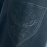 Close-up of the Ellis Rugby logo on the All Blacks 1983 Classic Rugby Shirt, featuring a vintage-style rugby ball and eagle crest with the year 1871.