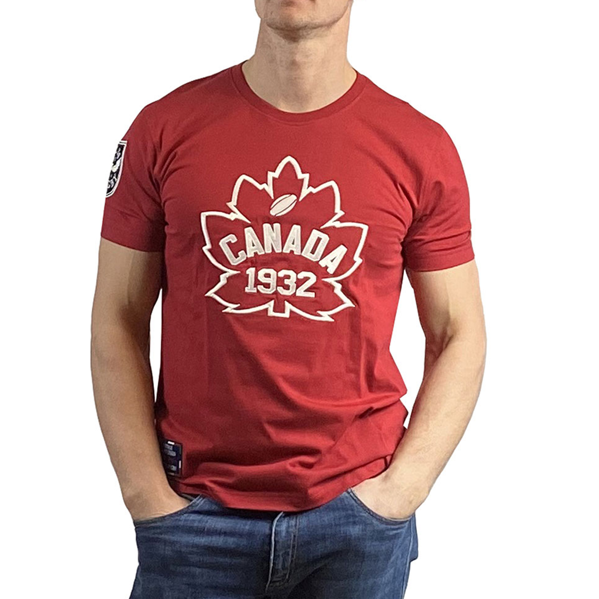 The person is wearing a Canada Rugby 1932 T-Shirt by Ellis Rugby, which is red with a white maple leaf and "Canada Rugby" text, paired perfectly with blue jeans.
