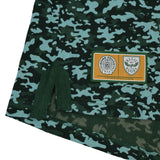 Hem of the Bomb Squad Bench T-Shirt by Ellis Rugby featuring a rectangular patch with the Bomb Squad and Ellis Rugby logos on a green camo-patterned fabric.