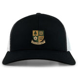 The EMB S&S Activewear Exiles Rugby Football Club Retro Trucker Cap features a black and white design with a gold and green crest on the front and an adjustable snapback closure.