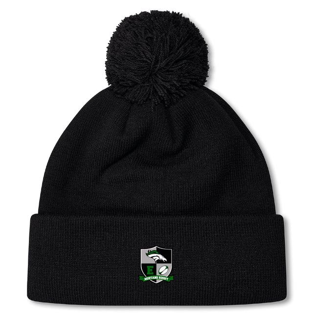 The Eagle High Mustangs Pom Pom Beanie by EMB Canterbury is a black knit hat with a pom-pom, an embroidered eagle and rugby ball logo with green accents on the cuff, and a cozy fleece lining for extra warmth.