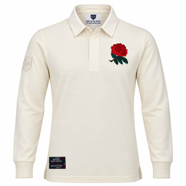 The Ellis Rugby England Rugby 1991 Shirt 1992 Grand Slam features cream long sleeves, a red rose emblem on the left chest, a patch on the left sleeve, and a black label above the hem. Inspired by England’s iconic 1992 Grand Slam victory, this shirt pays tribute to classic rugby heritage.