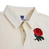 Introducing the England Rugby 1991 Shirt 1992 Grand Slam by Ellis Rugby—a cream-colored collared shirt featuring a red rose embroidered on the left chest, inspired by England’s classic 1991 rugby kit. This authentic piece showcases Ellis Rugby’s signature heritage details, including a visible blue and white tag inside the collar. Perfect for celebrating England’s Grand Slam victory, this shirt combines timeless style with proud tradition.