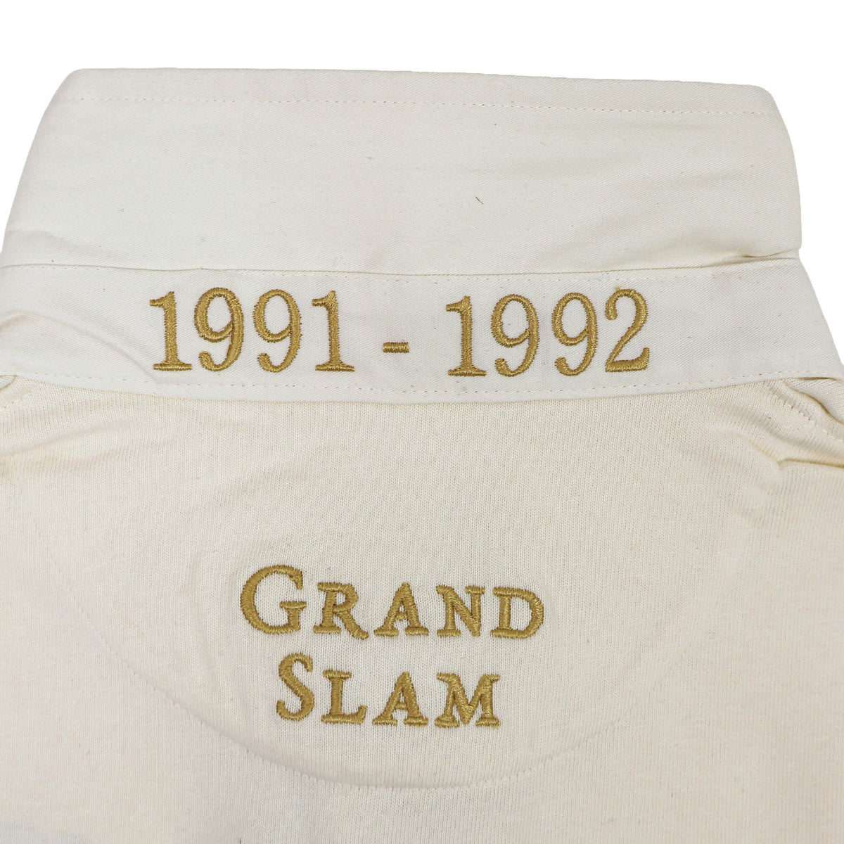 Close-up of the England Rugby 1991 Shirt 1992 Grand Slam by Ellis Rugby’s white collar, featuring “1991 - 1992” and “GRAND SLAM” embroidered in gold thread—an iconic design from Ellis Rugby.