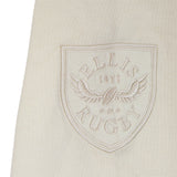 A cream fabric patch with a shield featuring the “ELLIS RUGBY” text, a winged rugby ball, and the year 1871—all embroidered in white thread—this timeless accessory by Ellis Rugby is inspired by the legacy of the England Rugby 1991 Shirt 1992 Grand Slam.