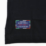 A black fabric featuring a stitched label that reads “Vintage Rugby Union EST 1871 by Ellis Rugby,” bordered by colorful stripes, pays homage to rugby heritage—an iconic style inspired by the classic traditions of New Zealand Rugby, as seen in the New Zealand Rugby 1924 Polo by Ellis Rugby.