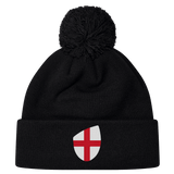 The EMB Canterbury England Shield Pom Pom Beanie features a black knit design with a playful pom-pom and an England flag patch on the front.