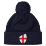 The England Shield Pom Pom Beanie by EMB Canterbury is a navy blue beanie featuring a prominent shield emblem with a red cross on a white background.