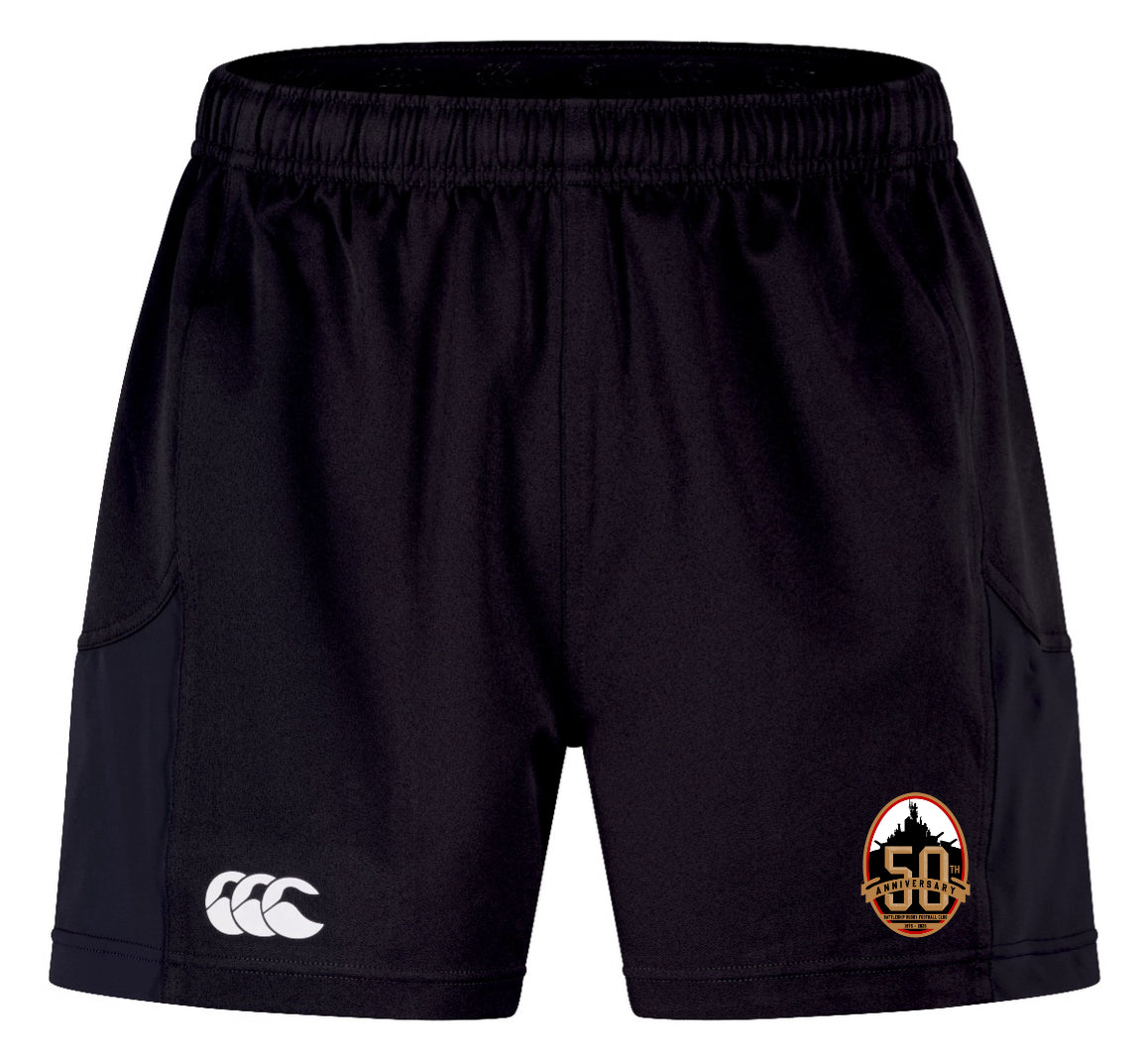 The EMB Canterbury Battleship Rugby Club 50th Anniversary Advantage Short 2.0 has an elastic waistband, a white Canterbury logo on the left leg, and an orange and black team logo on the right—comfortable, sustainable sportswear.