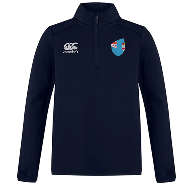 The Fiji Club Shield 1/4 Zip Training Top from EMB Canterbury features a half-zip front with a navy blue design. It displays the Canterbury logo on the left and a blue shield with Union Jack and red crest on the right, capturing the essence of premium tops.