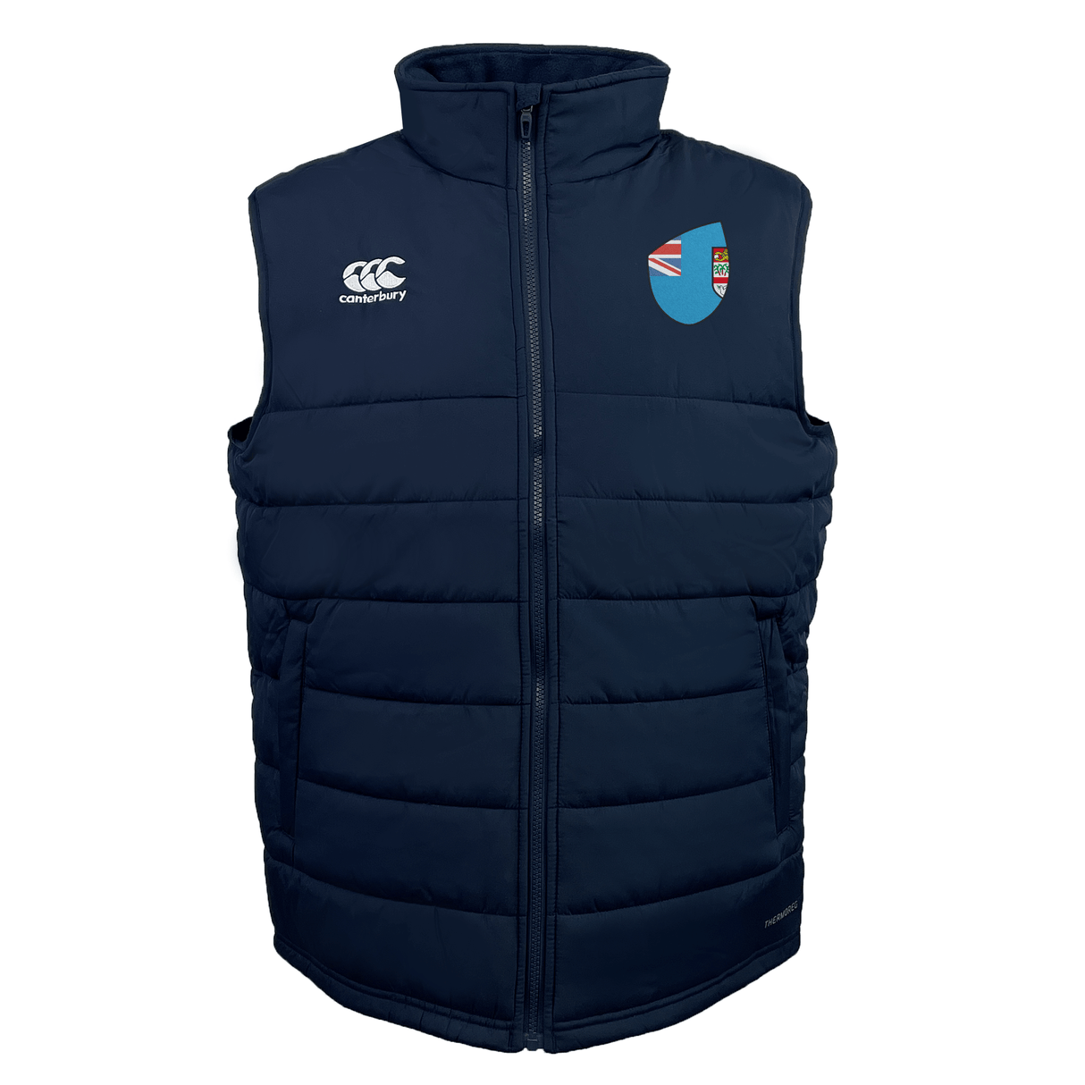 The EMB Canterbury Fiji Shield Core Gilet is a dark blue padded vest featuring Thermoreg insulation, a high collar, the Canterbury logo on the left, and a shield emblem on the right.