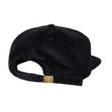 The EMB Weld Nations of Rugby Canada Corduroy Field Trip Cap is a black baseball cap with an adjustable strap and a small brown tag, offering classic style and timeless appeal.