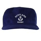 The EMB Weld Nations of Rugby Scotland Corduroy Field Trip Cap is a navy blue cap with "Scotland Rugby" and a white thistle emblem embroidered on the front—an ideal accessory for dedicated rugby fans.