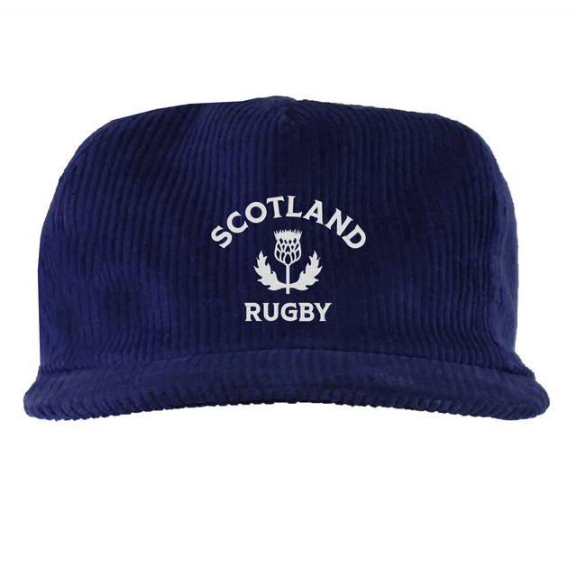The EMB Weld Nations of Rugby Scotland Corduroy Field Trip Cap is a navy blue cap with "Scotland Rugby" and a white thistle emblem embroidered on the front—an ideal accessory for dedicated rugby fans.