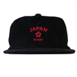 The EMB Weld Nations of Rugby Japan Corduroy Field Trip Cap features black corduroy, red “JAPAN” and “RUGBY” embroidery, and a striking central red emblem—ideal for rugby fans supporting Japan.