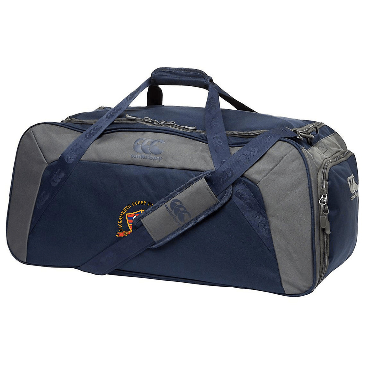 The EMB Canterbury Sacramento Rugby Football Club Holdall Duffle Bag is a navy blue and gray duffle with top handles, a shoulder strap, zippered main compartment, and a small embroidered logo on the side.