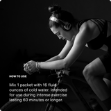 A person wearing headphones rides a stationary bike indoors. Text shares mixing instructions for Momentous Fuel 10-Travel Packs by Momentous, a carb electrolyte formula made to sustain energy and boost endurance during intense workouts over 60 minutes.
