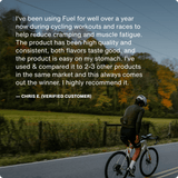 A cyclist rides on a road bordered by grass and trees, with a customer testimonial about Momentous Fuel’s clean ingredients from Momentous displayed over the image.