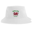 The Nations of Rugby Wales Rugby Sustainable Bucket Hat by EMB S&S Activewear features a white design with the red Welsh dragon and green "WALES RUGBY" text on the front, crafted from recycled polyester for an eco-friendly choice.