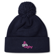 The Girls Rugby Pom Pom Beanie by Canterbury, featuring a navy blue knit design with a pom-pom and the "girls rugby" logo in pink and white on the cuff, is perfect for chilly days. Brand: EMB Canterbury.