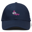The Girls Rugby Flexfit Drill Cap by Canterbury from EMB Canterbury is a dark blue cap with a curved brim, featuring an embroidered "girls rugby" logo in pink and white on the front.