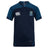 The Gretna United Rugby Vapodri Evader Jersey by Canterbury, from EMB Canterbury, is a navy short-sleeve V-neck shirt with dark blue shoulder panels, Goldington Academy logos on the chest, and moisture-wicking technology for comfort.