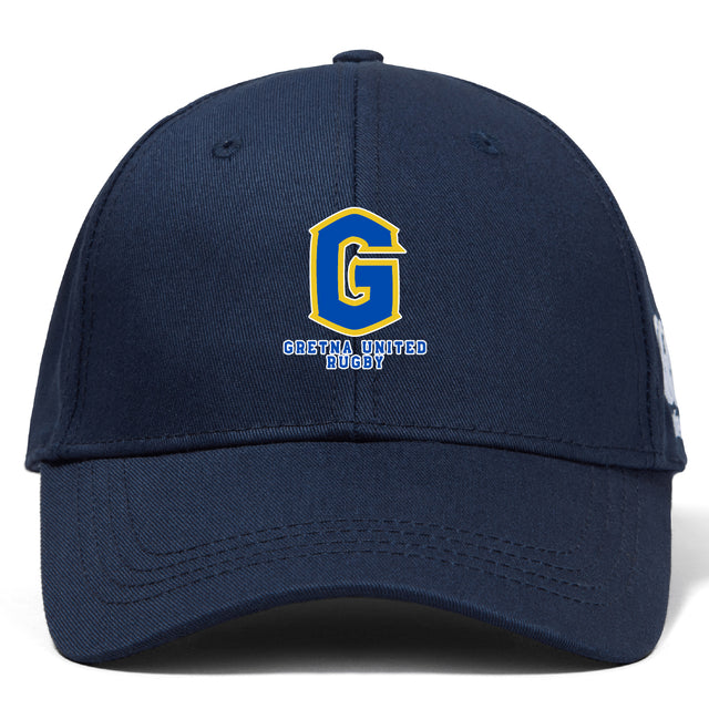 The EMB Canterbury Gretna United Rugby Flexfit Drill Cap features a navy blue design with a large yellow and blue embroidered "G" logo and "Gretna United Rugby" text on the front.