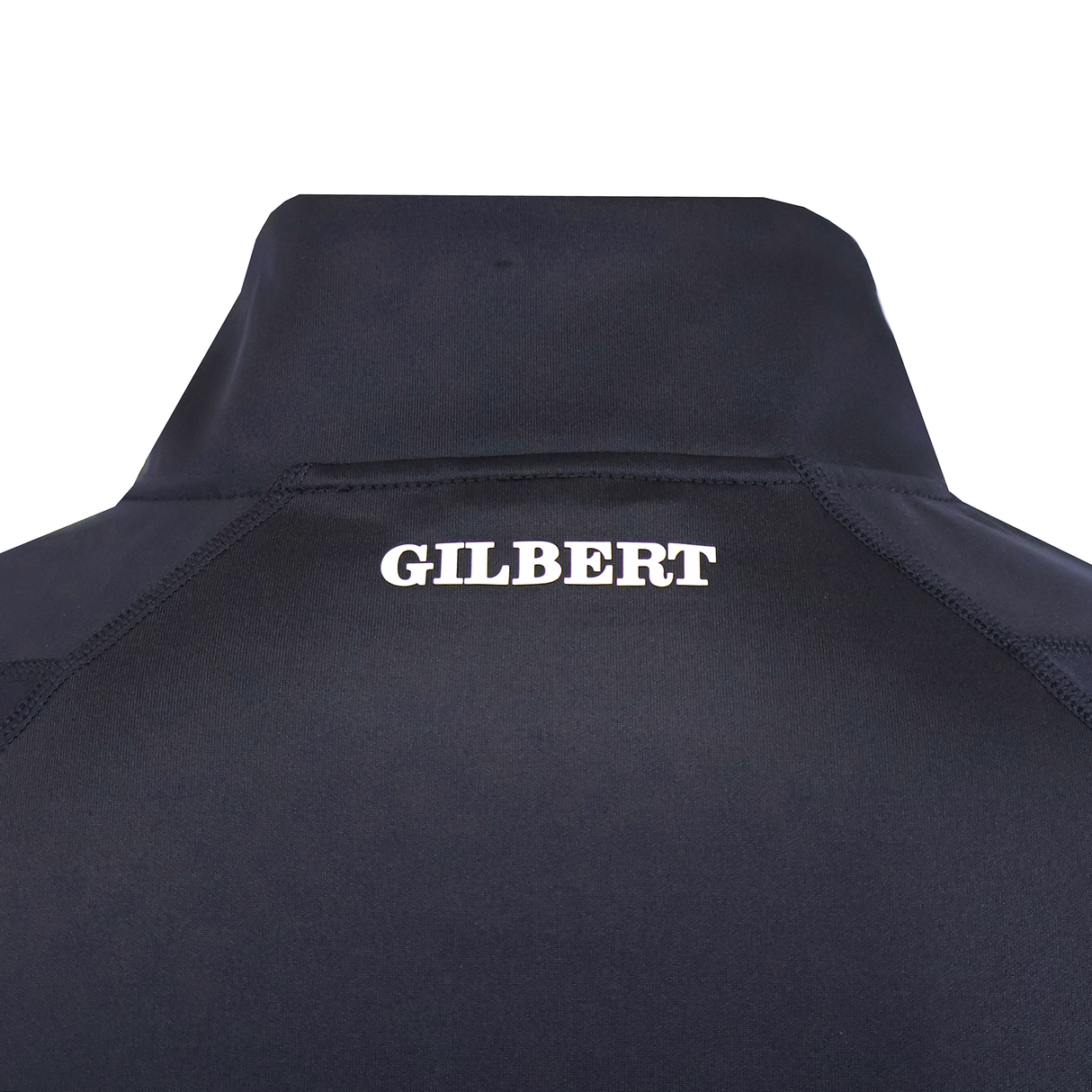 Close-up of the upper back of a dark Gilbert GTS 1/4 Zip Poly Pullover by Gilbert, featuring "GILBERT" printed in bold white letters.