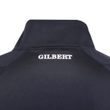 Close-up of the upper back of a dark Gilbert GTS 1/4 Zip Poly Pullover by Gilbert, featuring "GILBERT" printed in bold white letters.
