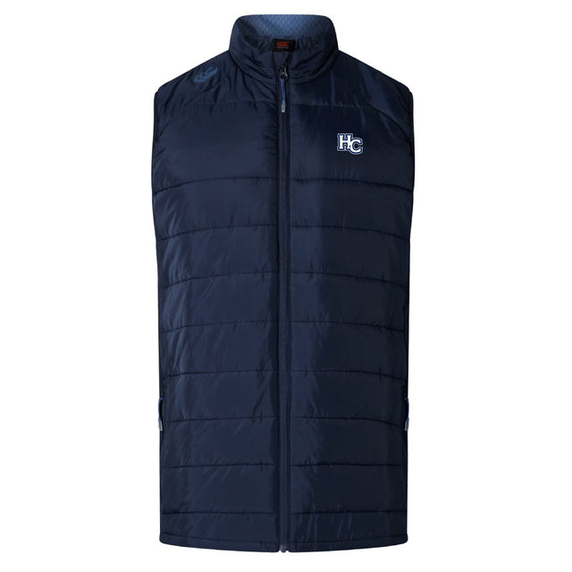 The Holy Cross Elite Microlite Gilet by EMB Canterbury is a navy blue, quilted, sleeveless insulated vest with a zip front and "HC" logo on the left chest.