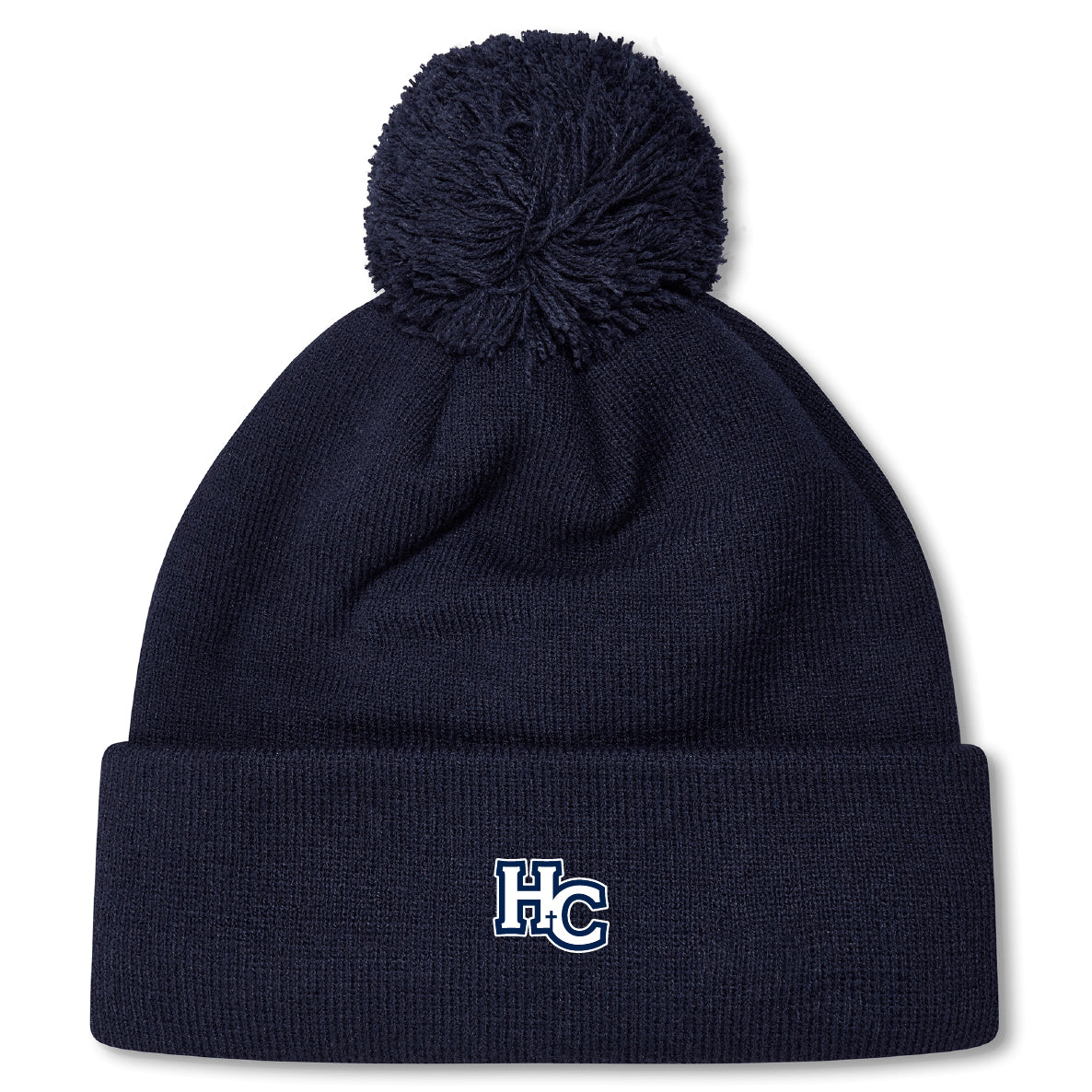 The Holy Cross Pom Pom Beanie by EMB Canterbury features a navy blue knit design, playful pom-pom, and an “HC” logo embroidered on the front cuff—a classic rugby bobble hat look.