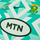 Close-up of a South African rugby jersey with the Springboks logo, Nike logo, South Africa Rugby emblem, and MTN sponsorship prominently displayed on a geometric green and white background. Just In: The latest **Springboks Replica Away Jersey by Nike**.