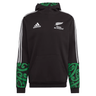 Introducing the Maori All Blacks Performance Hoodie by adidas, a striking black rugby hoodie flaunting "Māori All Blacks" text and a silver fern emblem. This performance piece proudly displays the iconic Adidas logo, complemented by white stripes and vibrant green Māori patterns on its sleeves and hood, perfectly merging style with athletic heritage.