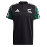 Maori All Blacks Performance Polo by adidas showcases a striking black design with the classic white Adidas logo and "Māori All Blacks" text, accompanied by a fern emblem on the front. The shoulders are enhanced with a green Māori pattern, while three white stripes adorn the sleeves. It also features moisture-wicking AEROREADY technology for added comfort.